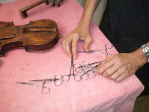 Surgical Precision: Discarded medical tools from Elain Fillion’s nursing years are repurposed to mend fiddles and guitars. (Photo by D.C. Bloom)